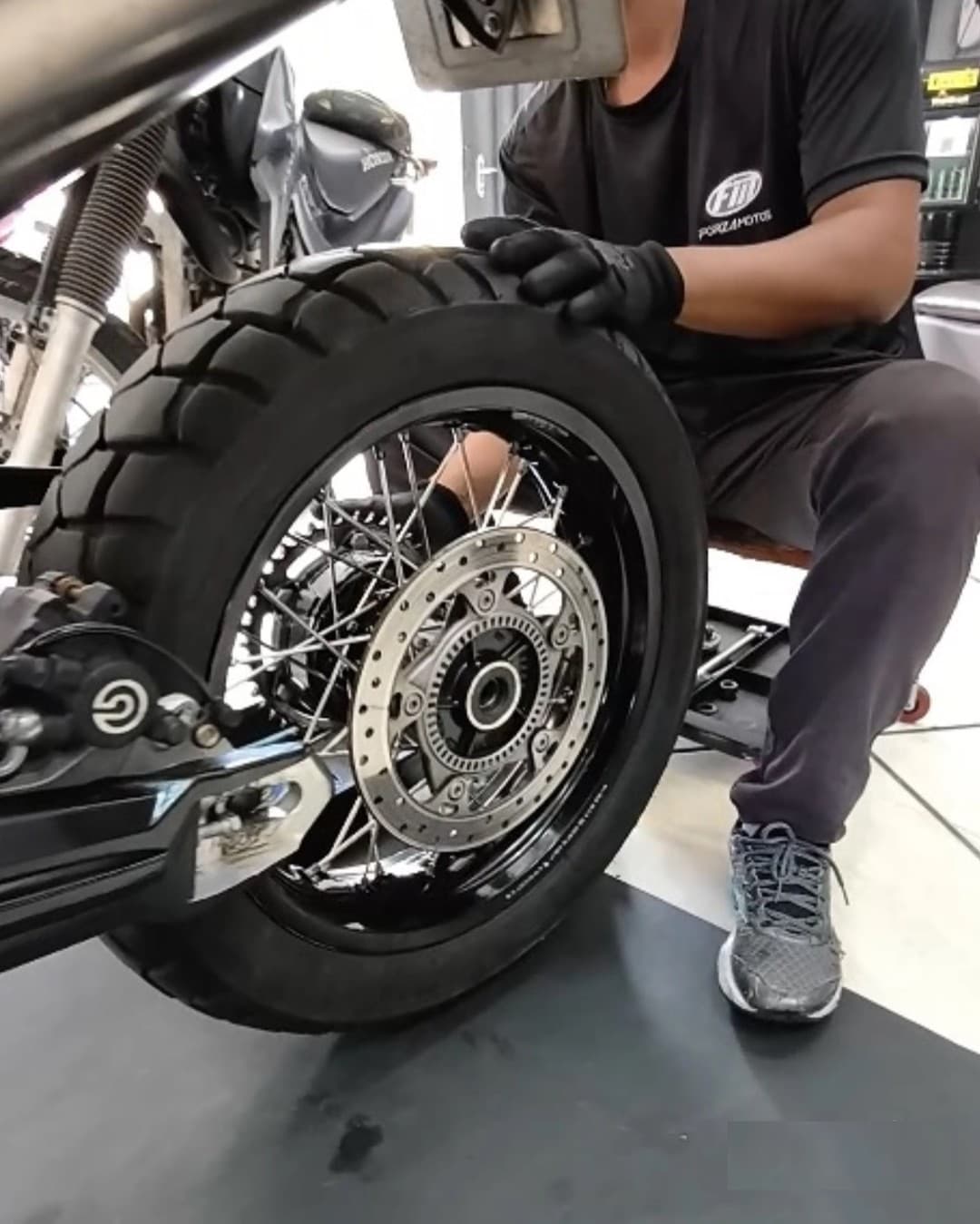 Mecânico Forza Motos realizando troca de pneu traseiro